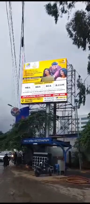 Outdoor LED display board mounted above a fuel station forecourt in Bengaluru