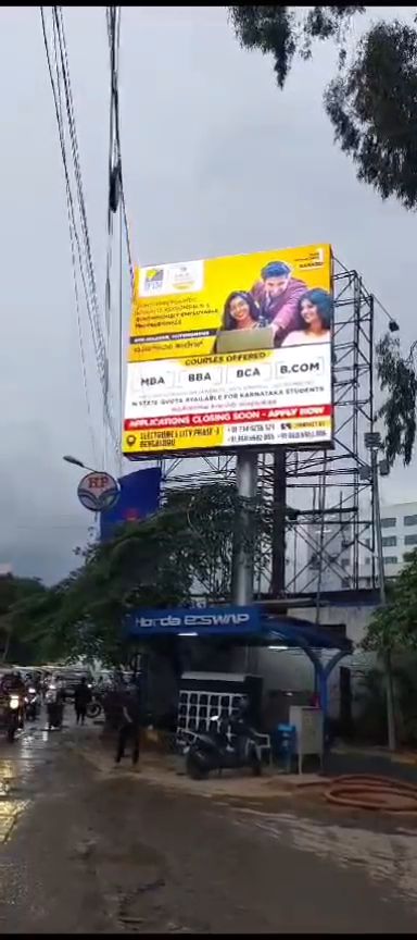 Outdoor LED display board mounted above a fuel station forecourt in Bengaluru