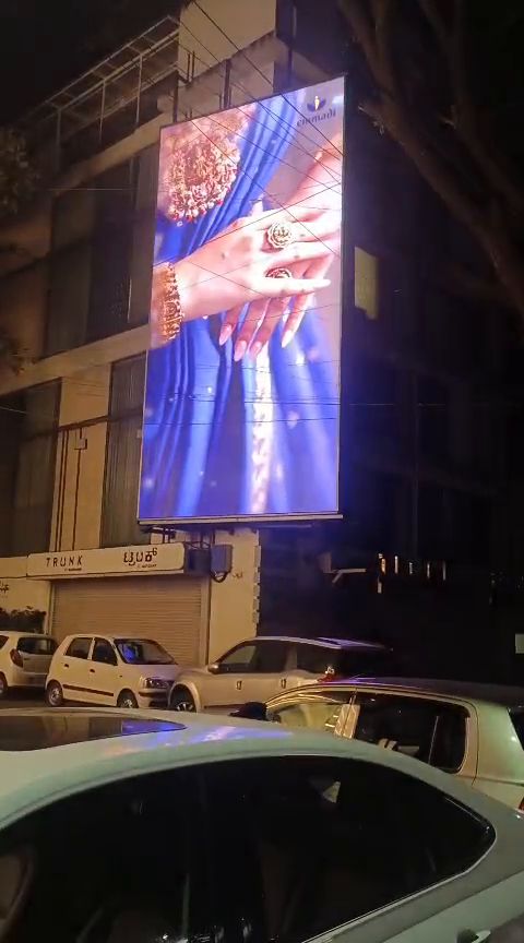 Vertical outdoor LED display on a building facade at night