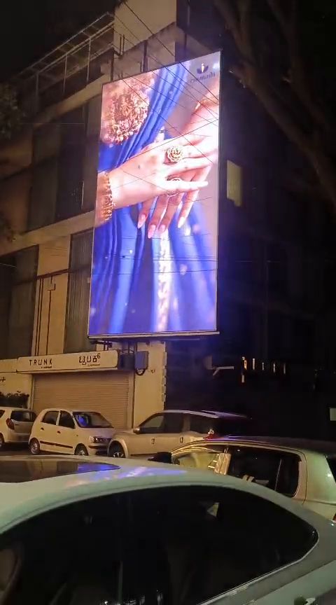 Vertical outdoor LED display on a building facade at night
