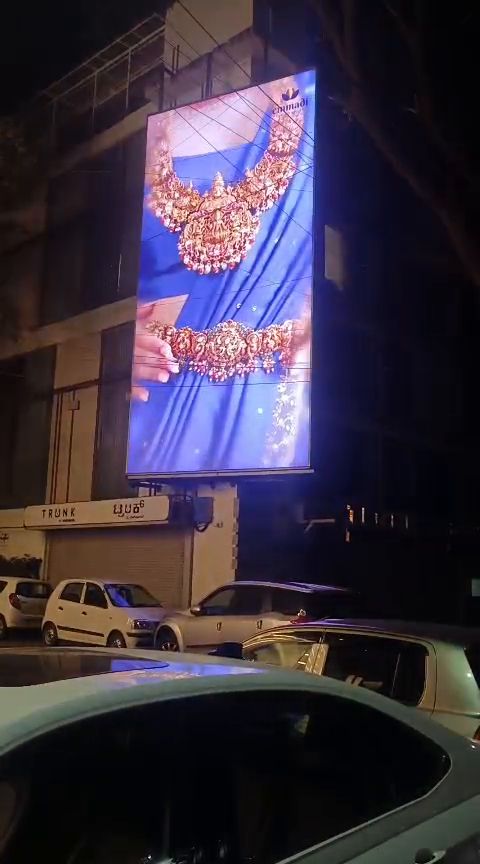 Vertical outdoor LED display on a building facade at night
