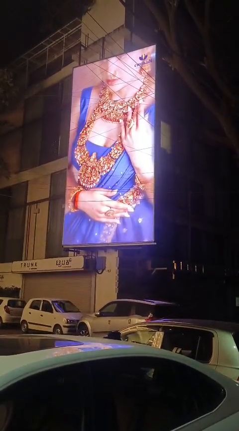 Vertical outdoor LED display on a building facade at night