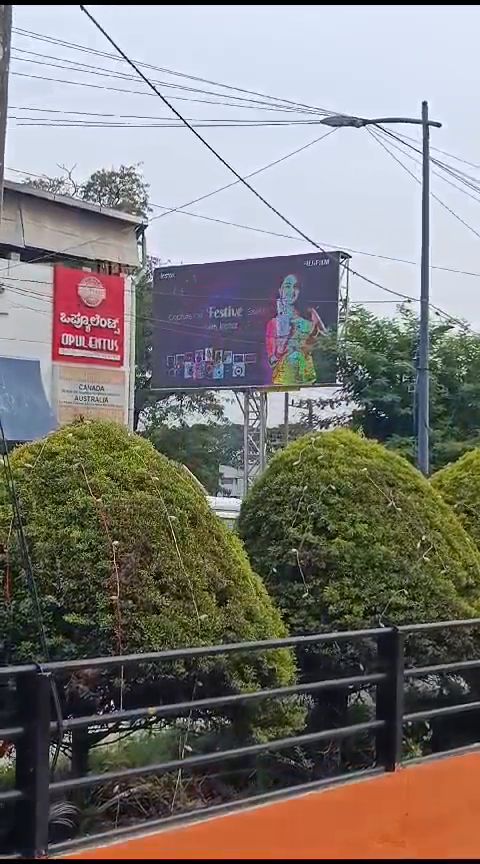 Outdoor LED billboard beside a landscaped commercial frontage