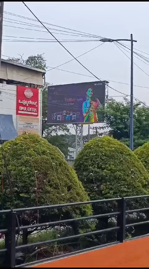 Outdoor LED billboard beside a landscaped commercial frontage