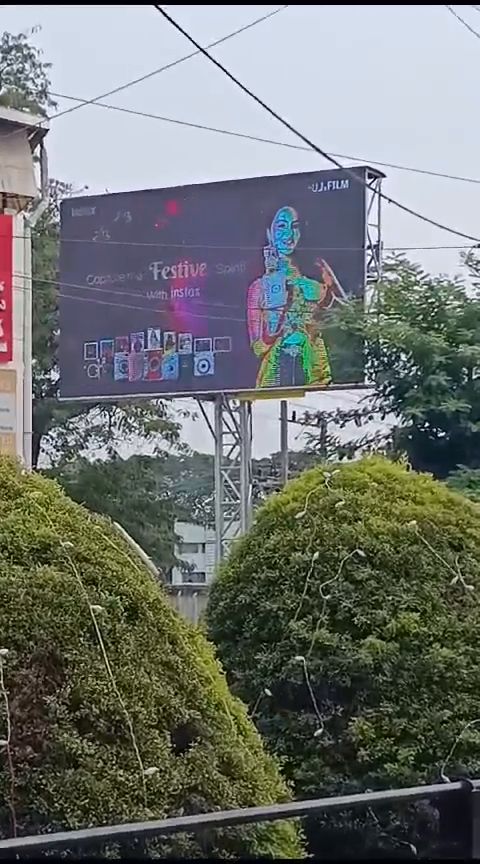 Outdoor LED billboard beside a landscaped commercial frontage