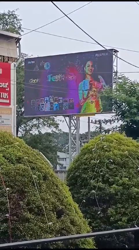 Outdoor LED billboard beside a landscaped commercial frontage