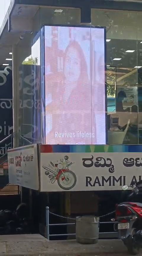 Freestanding LED digital standee on a footpath outside a shopfront