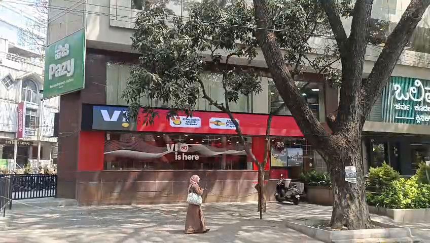 Wide LED display band running across a shop facade