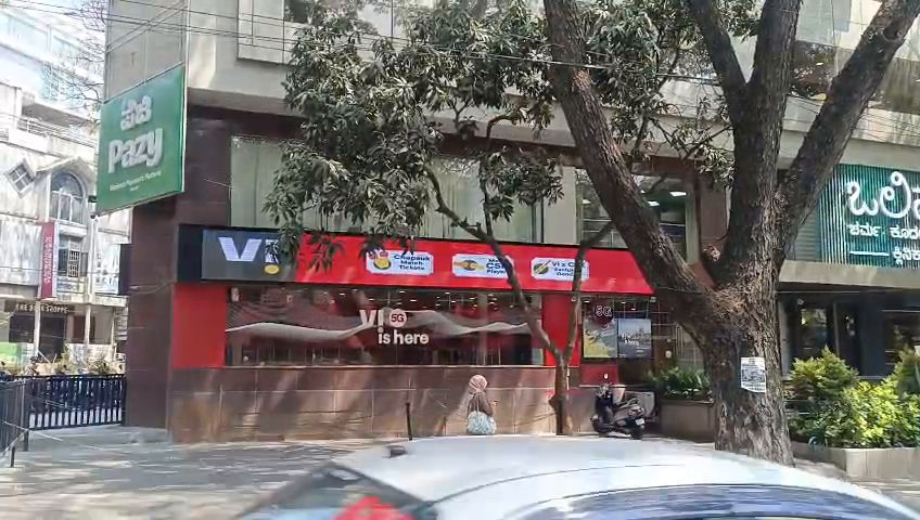 Wide LED display band running across a shop facade