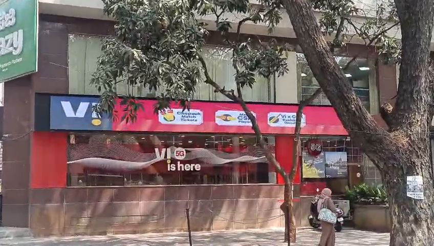 Wide LED display band running across a shop facade