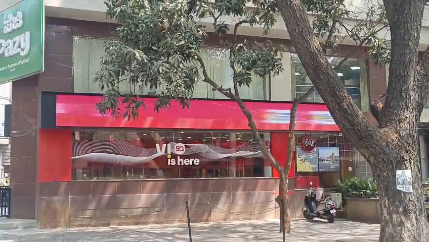Wide LED display band running across a shop facade