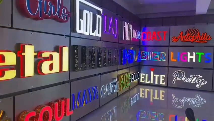 Showroom wall of illuminated channel letters and LED neon lettering in English and Kannada