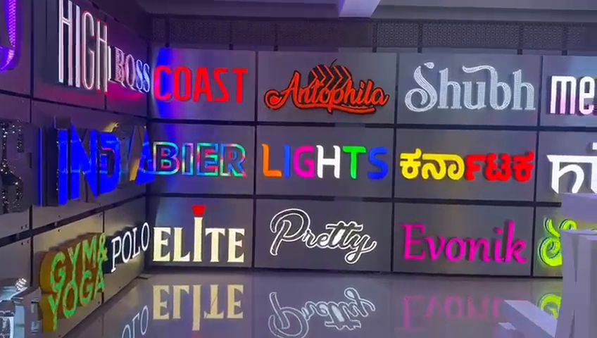 Showroom wall of illuminated channel letters and LED neon lettering in English and Kannada